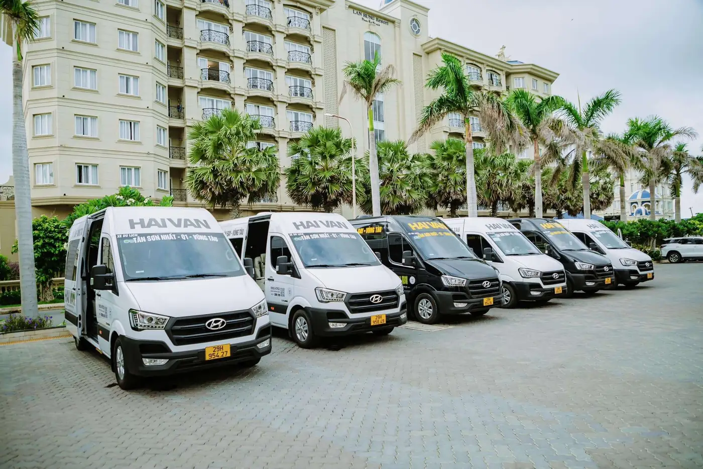 A convoy of Hai Van limousine buses on a city street
