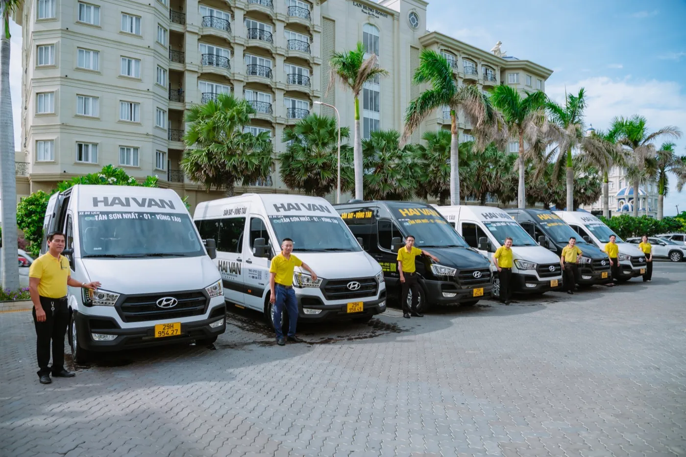 Hai Van staff in yellow uniforms beside the limousine fleet in front of a Vung Tau hotel